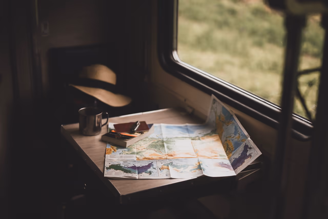 Un mapa de carreteras de papel extendido sobre una mesa dentro de una camioneta camper